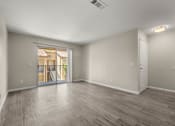 Thumbnail 11 of 24 - an empty living room with a door to a balcony