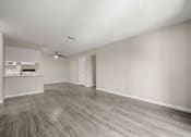 Thumbnail 13 of 24 - an empty living room and kitchen with wood flooring