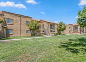 Thumbnail 7 of 24 - a row of brick apartments with grass and trees