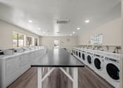 Thumbnail 5 of 24 - a laundry room with washes and dryers and a table