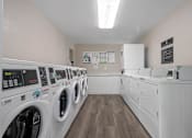 Thumbnail 5 of 18 - a laundry room with washers and dryers and a row of washing machines