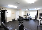 Thumbnail 8 of 20 - A gym with treadmills, elliptical machines, and other exercise equipment.