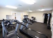 Thumbnail 6 of 20 - A gym with treadmills and elliptical machines.