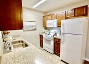 Thumbnail 14 of 15 - A kitchen with a white refrigerator, white oven, and white microwave.