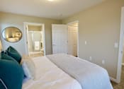 Thumbnail 11 of 15 - A bedroom with a large bed and a mirror on the wall.