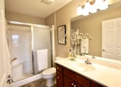 Thumbnail 5 of 15 - A bathroom with a toilet, sink, and shower.