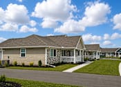 Thumbnail 11 of 42 - A row of houses with a blue sky and clouds above them.