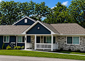 Thumbnail 3 of 42 - An apartment with a blue siding and a white porch.