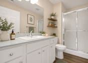 Thumbnail 23 of 42 - A white bathroom with a toilet, sink, and shower.
