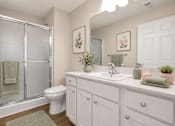 Thumbnail 32 of 42 - A white bathroom with a toilet, sink, and shower.