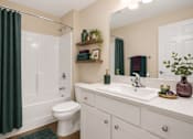 Thumbnail 41 of 42 - A white bathroom with a toilet, sink, and bathtub..