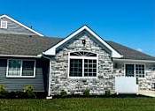 Thumbnail 5 of 36 - a stone house with a white fence in front of it