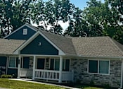Thumbnail 3 of 36 - a house with a gray roof and a white porch