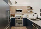 Thumbnail 7 of 39 - a kitchen with wood cabinets and stainless steel appliances