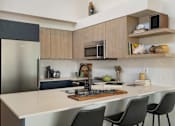 Thumbnail 21 of 39 - a kitchen with wooden cabinets and a white counter top