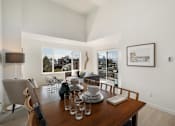 Thumbnail 22 of 39 - a dining room with a wooden table and chairs and a large window with a view of the