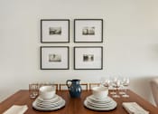 Thumbnail 29 of 39 - a dining table with plates and glasses on it and four pictures on the wall above