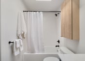 Thumbnail 20 of 39 - a bathroom with white walls and a white bathtub with a white shower curtain