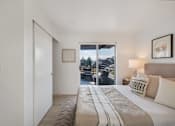 Thumbnail 33 of 39 - a bedroom with a bed and a door that leads to a balcony