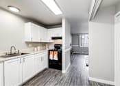 Thumbnail 10 of 15 - A kitchen with white cabinets and a black stove top oven.