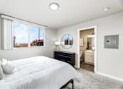 Thumbnail 12 of 15 - A bedroom with a large bed and a mirror on the wall.