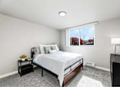 Thumbnail 13 of 15 - A bedroom with a large bed and a window overlooking a street.