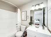 Thumbnail 14 of 15 - A bathroom with a toilet, sink, and mirror.