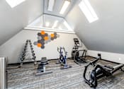 Thumbnail 15 of 15 - A gym with a row of exercise bikes and a wall hanging.