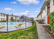 Thumbnail 1 of 15 - A pool surrounded by a fence with chairs around it.