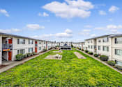 Thumbnail 2 of 15 - A row of houses with a green lawn in front.