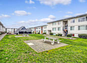 Thumbnail 3 of 15 - A sunny day at a residential area with a picnic table and benches.