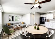 Thumbnail 5 of 15 - A modern living room with a grey couch, a wooden table, and a ceiling fan.