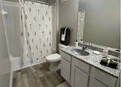 Thumbnail 5 of 13 - A bathroom with a toilet, sink, and shower curtain. at The Dawson Cartersville in Cartersville, GA 30191