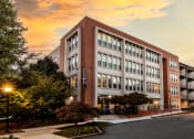 Thumbnail 2 of 31 - Building view leasing office with a sunset behind it at Mariposa Lofts, Atlanta, GA