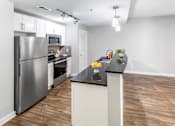 Thumbnail 10 of 42 - A kitchen with a refrigerator, microwave, oven, and sink. at West Inman Lofts, Atlanta, Georgia