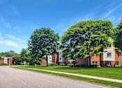 Thumbnail 11 of 12 - A row of houses with green trees in front at Rose Hill Estates, Norwich, CT, 06360