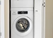 Thumbnail 5 of 10 - A white Whirlpool washing machine and dryer in a small laundry room.