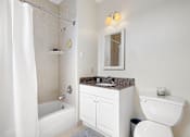 Thumbnail 9 of 10 - A white bathroom with a toilet, sink, and shower.