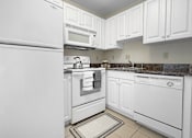 Thumbnail 7 of 10 - A kitchen with white appliances and cabinets.