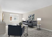 Thumbnail 2 of 12 - A living room with a grey sofa, a black chair, and a small table with a lamp on it at Rose Hill Estates, Norwich, CT, 06360
