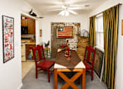 Thumbnail 14 of 15 - A dining room with a wooden table and chairs.