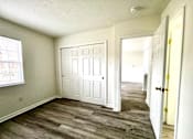 Thumbnail 12 of 15 - A room with a white door and a window.