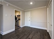 Thumbnail 1 of 17 - A kitchen area with a white door and a small fridge.