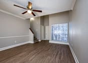 Thumbnail 4 of 17 - A room with a ceiling fan and wooden flooring.