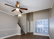 Thumbnail 16 of 17 - A room with a ceiling fan and a staircase.
