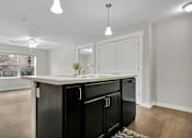 Thumbnail 25 of 25 - A kitchen with black appliances and white cabinets.
