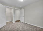 Thumbnail 14 of 25 - A room with two white doors and a carpeted floor.