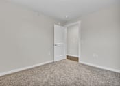 Thumbnail 7 of 25 - A room with a carpeted floor and a white door.