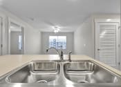 Thumbnail 12 of 25 - A kitchen with two sinks and a window.