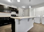 Thumbnail 2 of 25 - A kitchen with black cabinets and white appliances.